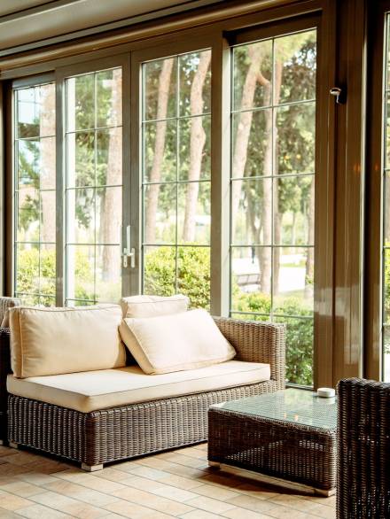 outdoor sofa with beige cushions and coffee table in front of the restaurant window